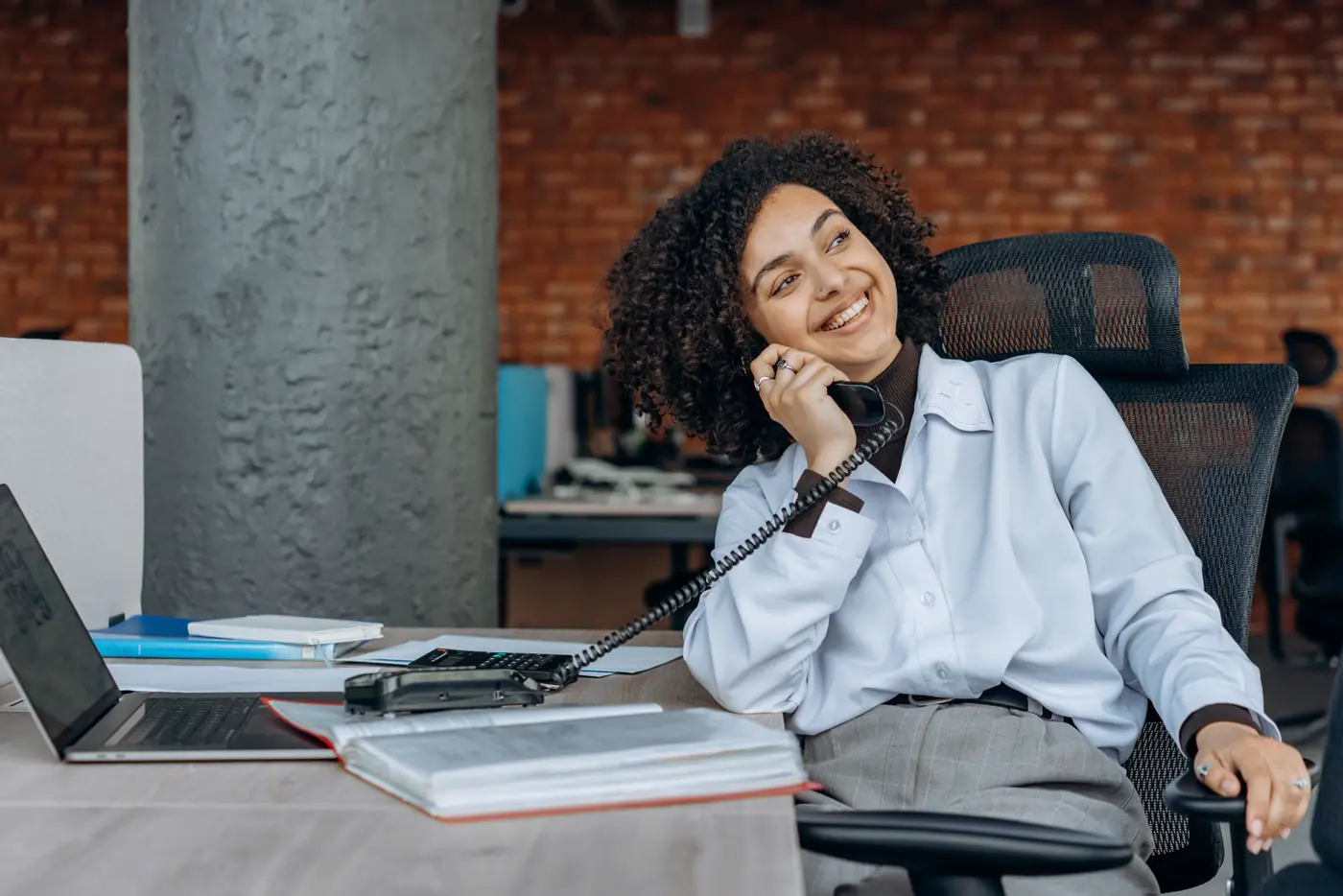 Friendly team member taking a client phone call in the office