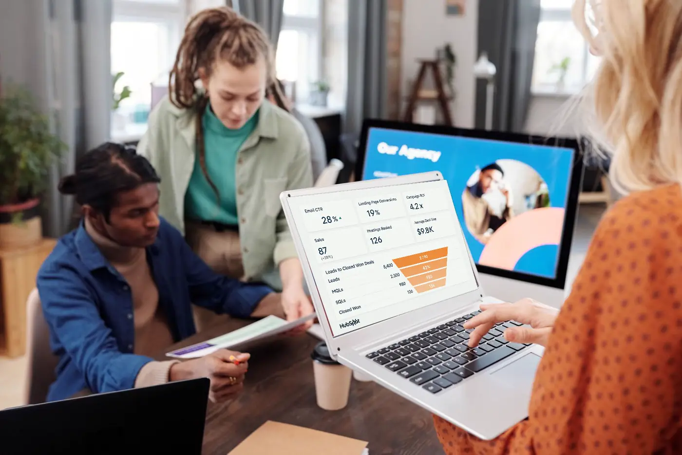 Team reviewing a HubSpot dashboard with conversion funnel on a laptop
